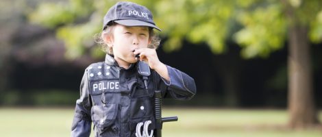 Little girl blowing whistles wearing police costumes